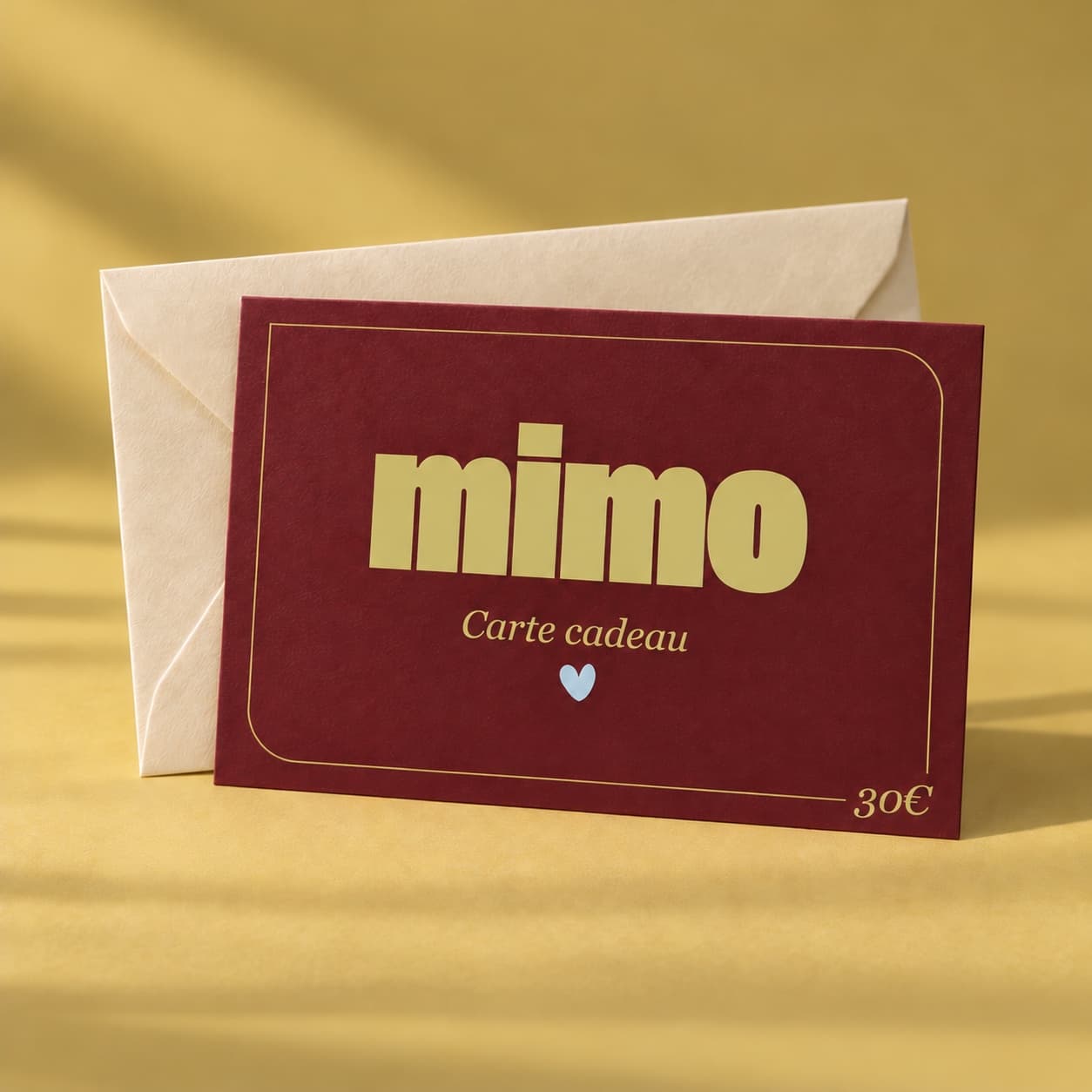 Carte cadeau MiMo de 30 euros, présentée avec une enveloppe crème sur fond jaune