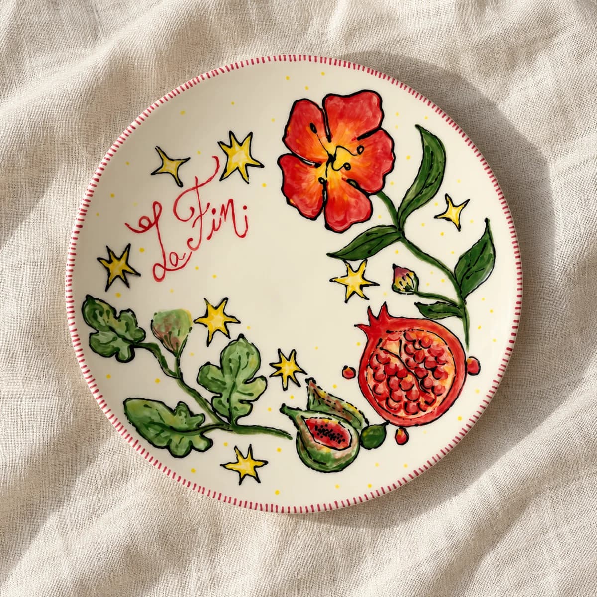 Assiette peinte de fleurs rouges, de figues, d’une grenade et d’étoiles jaunes