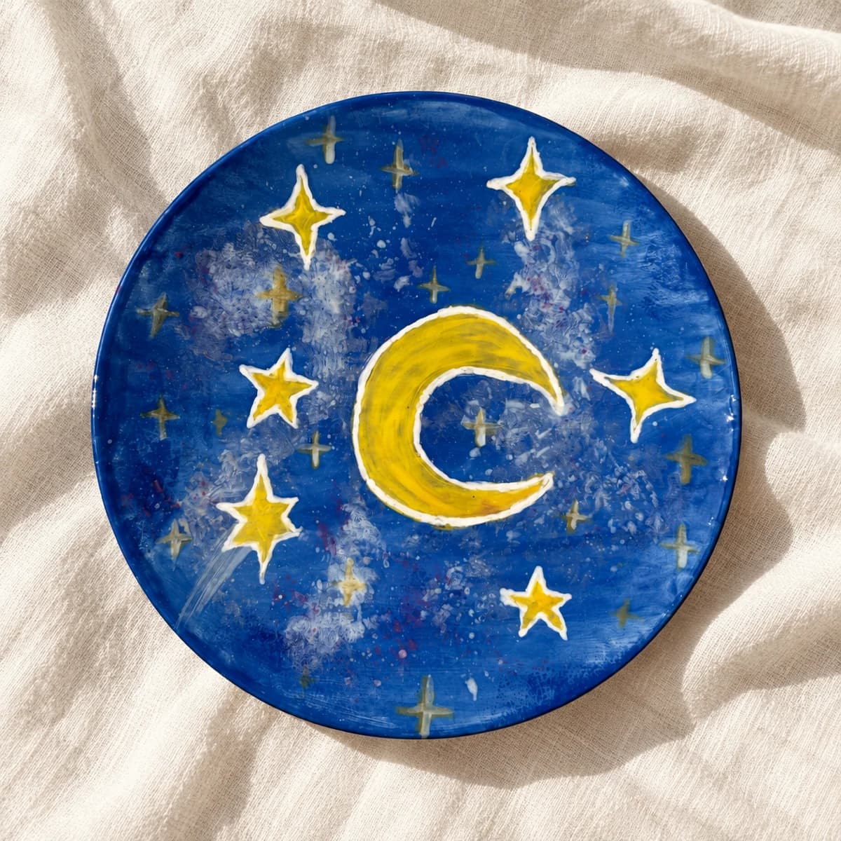 Assiette bleu nuit peinte d’une lune jaune et d’étoiles